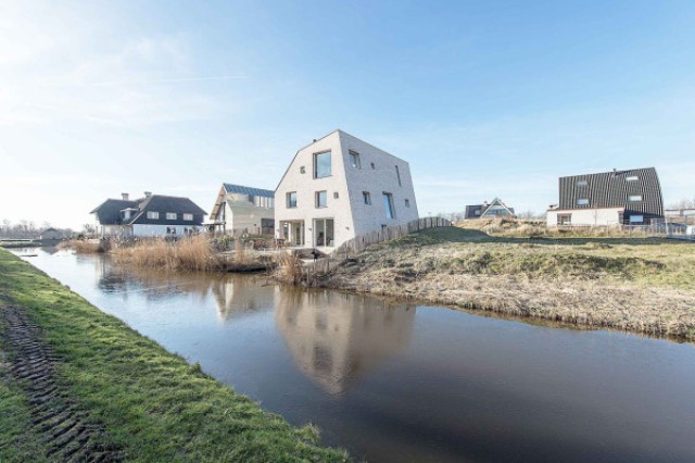 This modern house strikes at first sight with its sculptural shape and a fresh take on a gabled roof