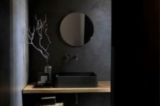 02 black walls, a black sink and a wooden counter and stool that add texture