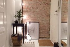 02 small decluttered entryway with an exposed brick wall, lights and a tall mirror