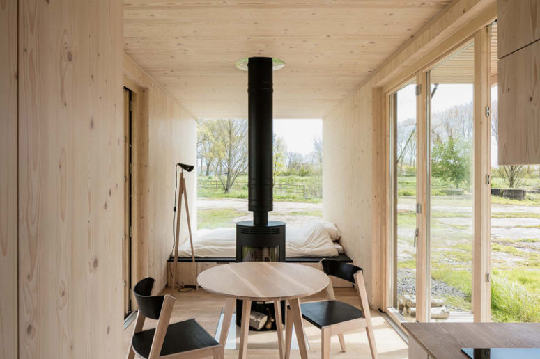 wood clad interior The inside is clad with light-colored warm woods to make it natural and cozy, and the furniture is contrasting black