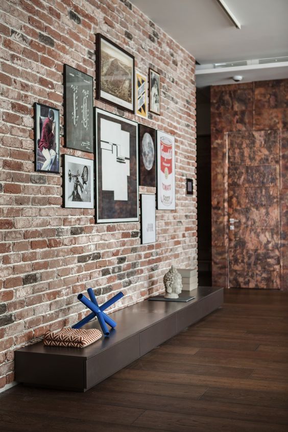 modern entryway with a traditional brick wall and a low cabinet that can be used as a bench