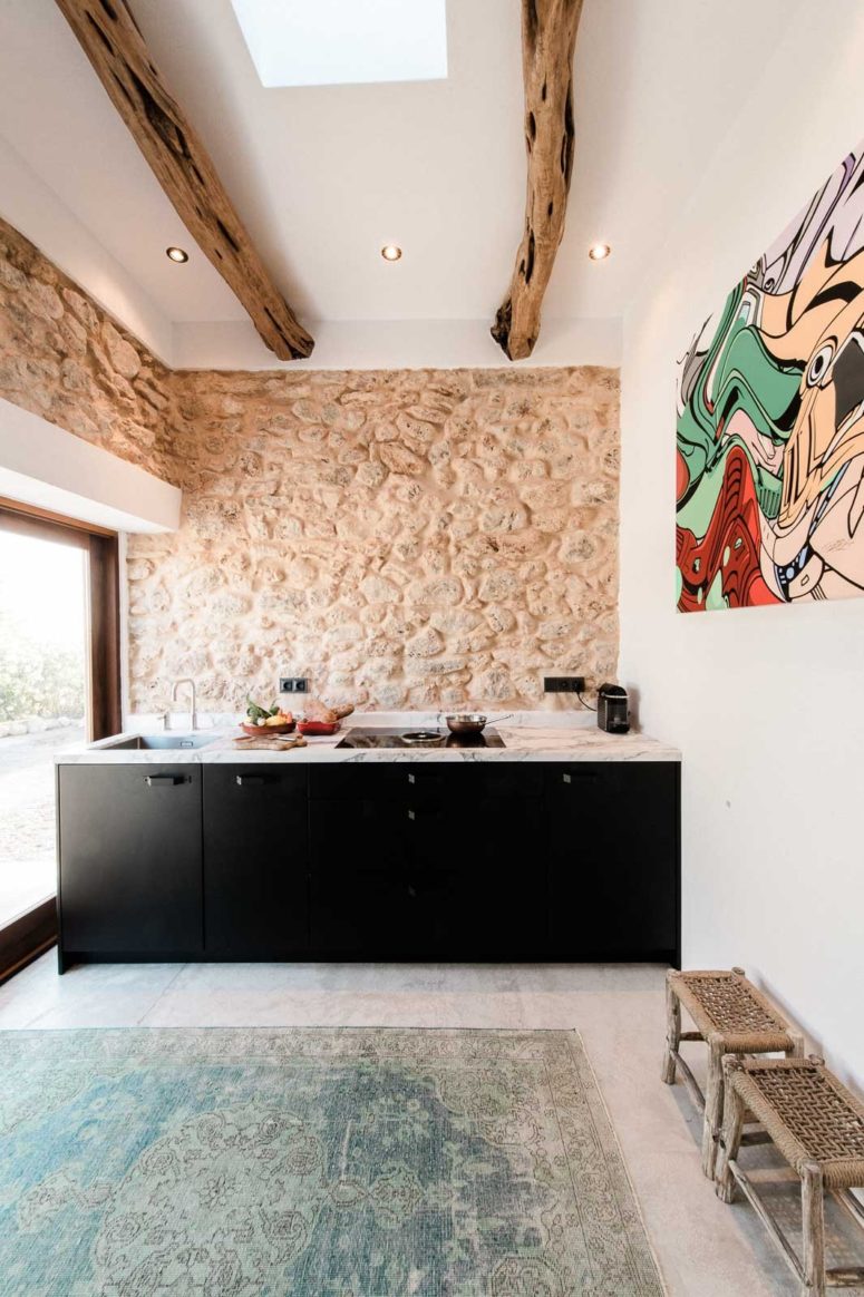 eclectic house The kitchen features original stone clad used as a backsplash and original exposed wooden beams yet minimalist furniture