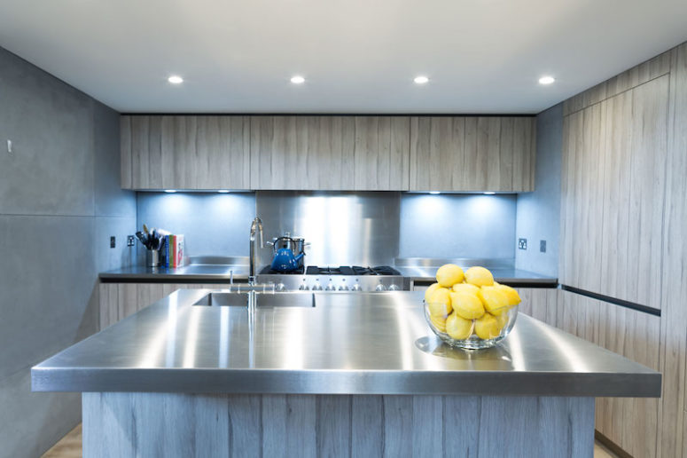 concrete kitchen The kitchen is decorated in light grey, concrete and stainless steel, there are a lot of lights