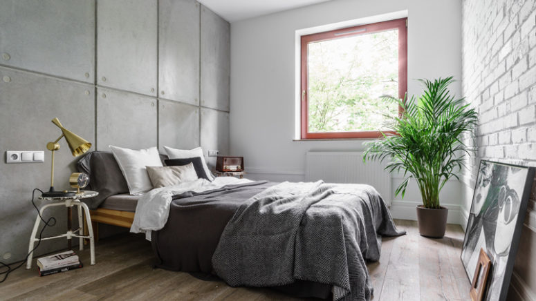 moody bedroom The bedroom is covered with concrete and brick panels, and potted greenery enliven the greyish space