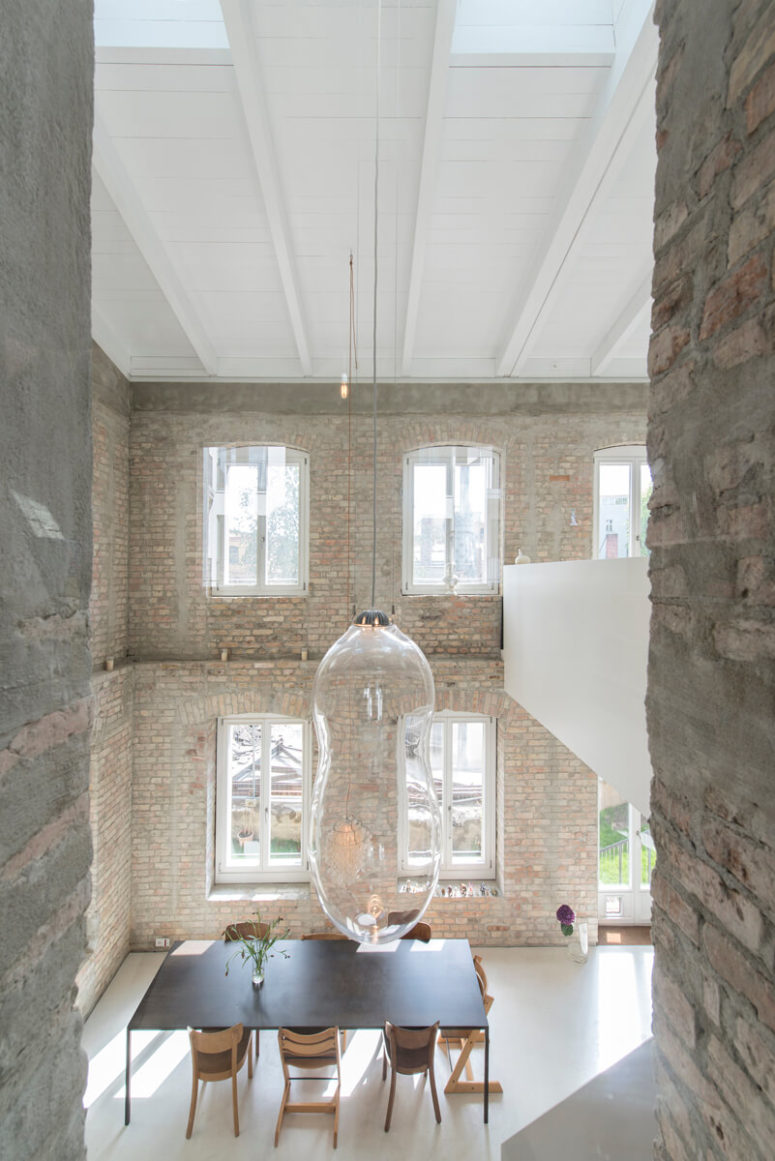 The dining area has a double height ceiling and is filled with light, I love the bubble-shaped pendant lamps