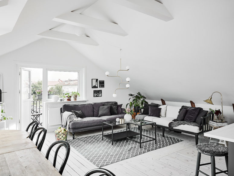 The living space features two sofas in grey and white, mid-century modern lamps and textiles bring coziness