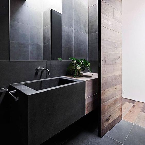 minimal bathroom space in black that is softened with reclaimed wood