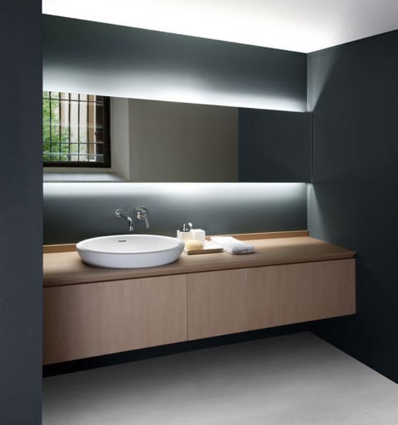 minimal countertop washbasin and gorgeous hidden lighting behind the mirror