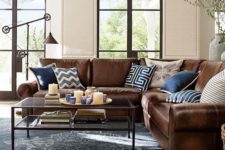 12 L-shaped brown leather sofa looks great and refreshed with navy and blue pillows