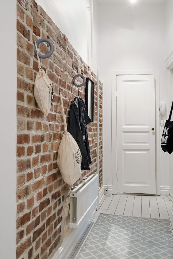 brick walls are great for attaching various hooks and holders, so it's a functional solution for an entryway