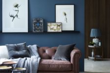 14 chic seating area with a brown sofa and a navy accent wall and textiles