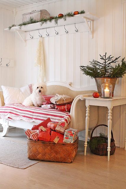 some ornaments, a small fir tree and gift boxes in a basket