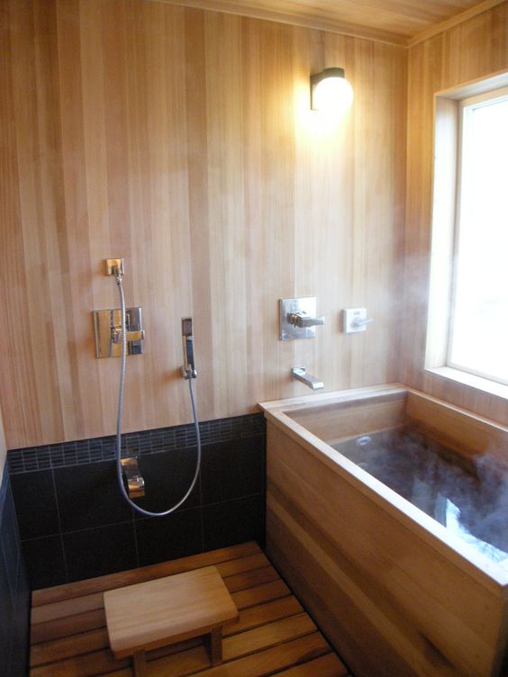 warm woods all over are highlighted with black tiles and the bathroom looks welcoming