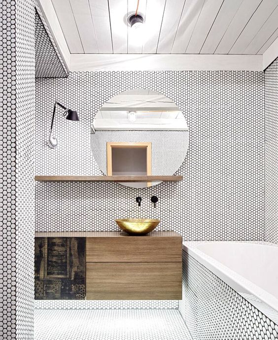 white penny tiles with black grout all over the bathroom give it a texture