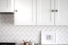18 kitchen backsplash clad in subway tiles with a diagonal herringbone pattern