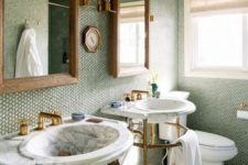 19 bathroom with brass and marble fixtures and a wall of moss-green penny tiles
