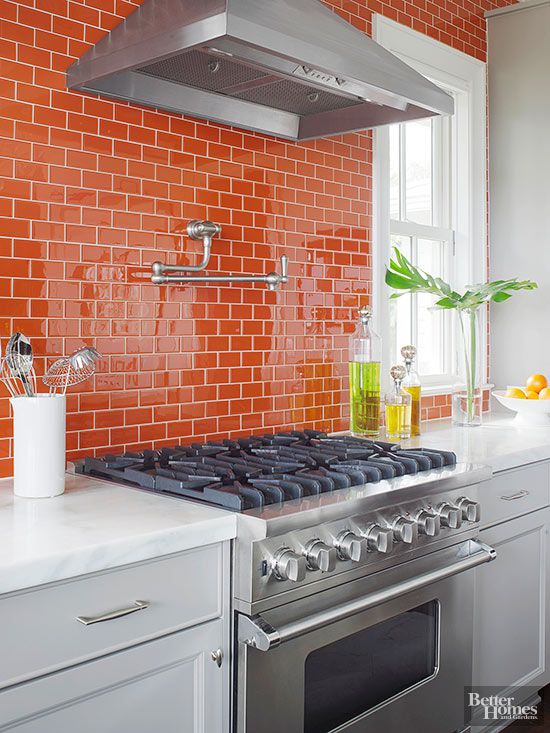 a white farmhouse kitchen with a bold orange subway tile backsplash and white countertops is a cool and vibrant space