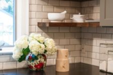 20 black kitchen countertops crisply contrast a white subway tile backsplash for a look that’s fresh and simple