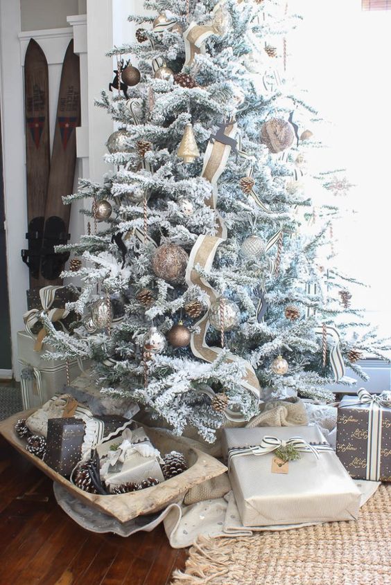flocked Christmas tree with copper ornaments and pinecones