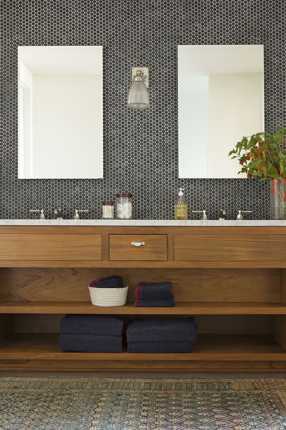 natural bathroom with black and grey penny tiles in the sink area
