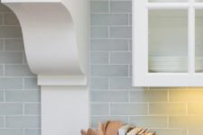 22 subway tiles in a pale blue-gray give depth to the backsplash and make the white cabinetry feel even more fresh