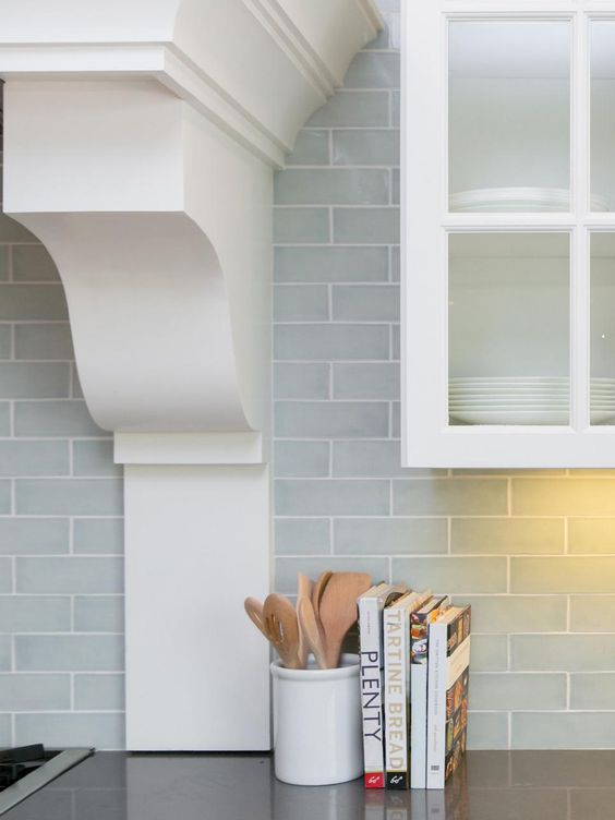 subway tiles in a pale blue-gray give depth to the backsplash and make the white cabinetry feel even more fresh