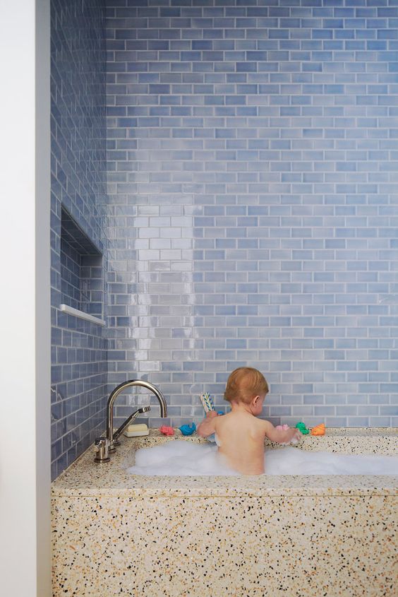 watery blue subway tiles and a terrazzo bath look so contrasting and cool together