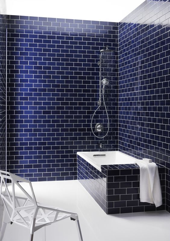 navy blue subway tiles on the walls and bathtub