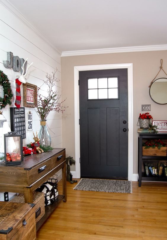 a faux deer head, a lantern filled with ornaments and an evergreen wreath