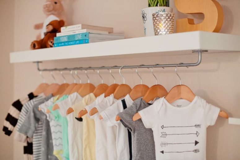 a Lack shelf with a rod underneath makes a perfect place to hang baby clothes in a nursery