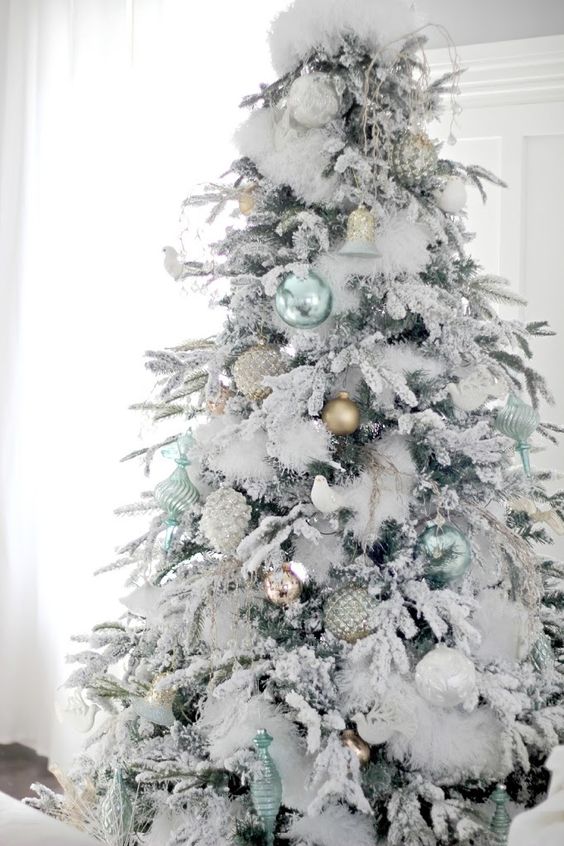 snowy Christmas tree with pastel ornaments not to distract attention from the tree