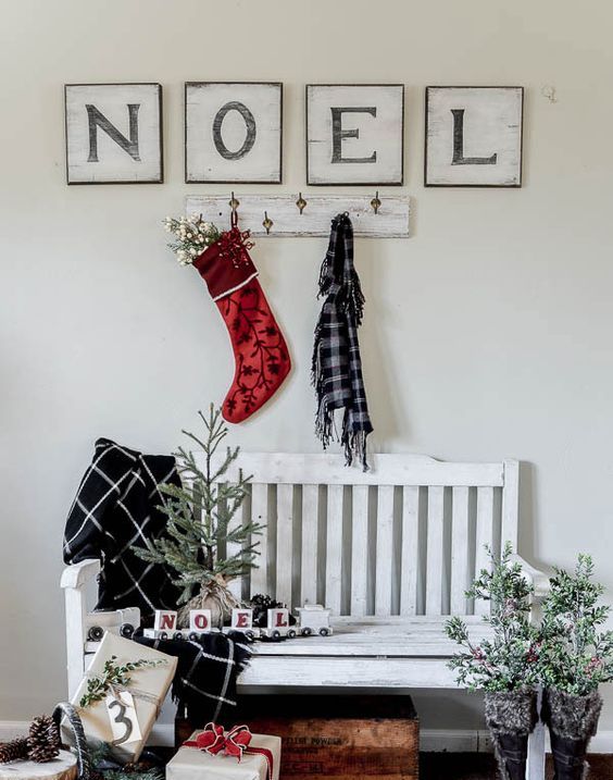 evergreen branches placed in boots, a small tree and gift boxes