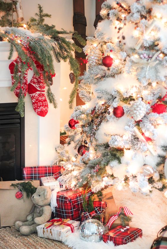 snowy tree wwith traditional red ornaments and whitewashed pinecones