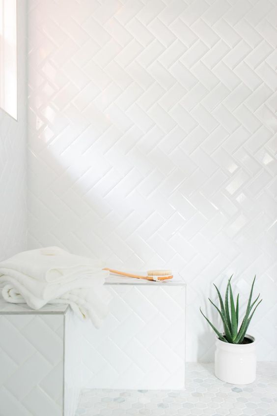 simple subway tiles with white grout in a herringbone pattern in the shower