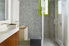 37 grey tiles on the walls, floor and in the shower contrast with lime green accents