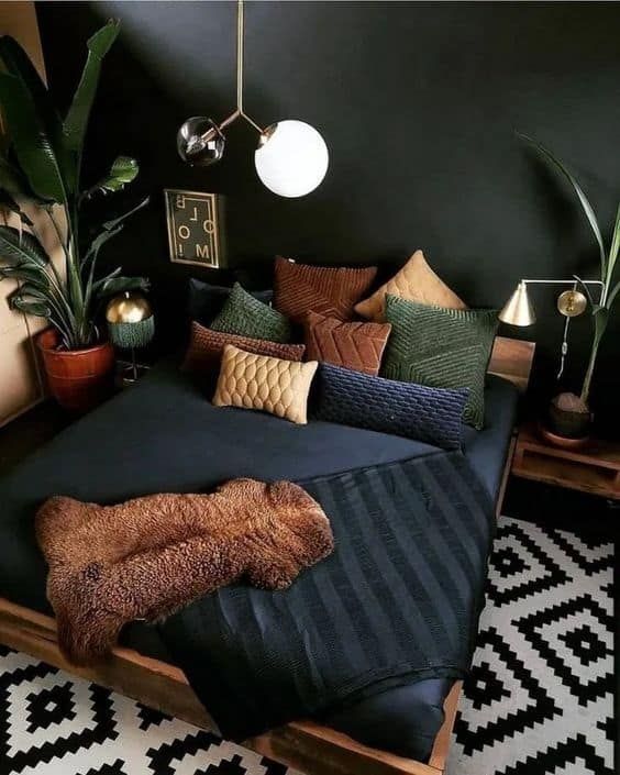 a moody bedroom with black walls, a stained bed with dark bedding, nightstands, potted plants and some decor plus a graphic rug