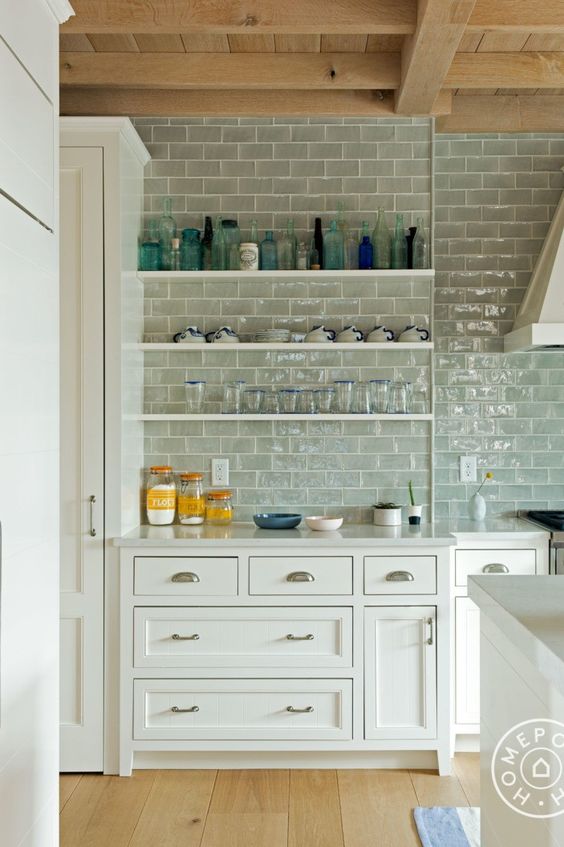 a white modern farmhouse kitchen with shaker cabinets, open shelves and grey subway tile on the whole wall