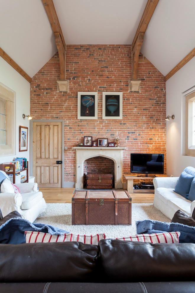 A mix a country and industrial styles in this living room works well. It features lots of cool brown things including two vintage trunks and cool blue pillows with fringes (Chris Snook)