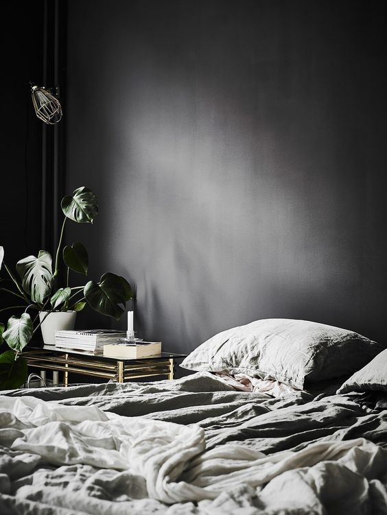 elegant bedroom with graphite walls and a refined gold and glass table