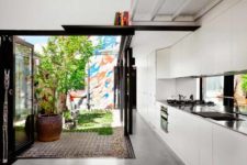 02 The kitchen is done in white, it’s modern and functional and the space is extended outdoors to the sunlit backyard