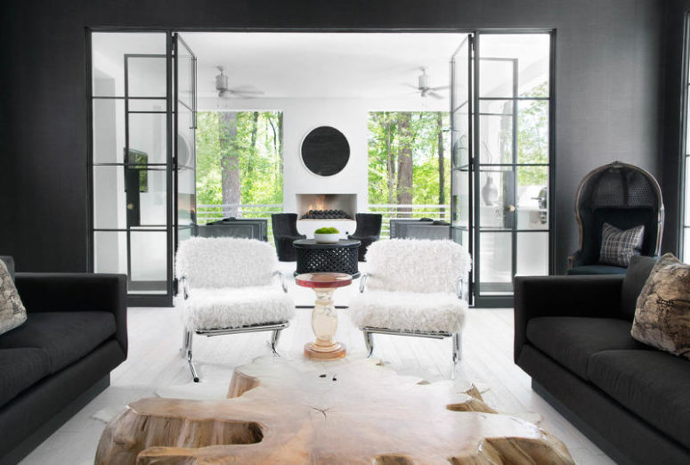 The living room has graphite grey walls and furniture, a large nautral shaped wooden coffee table and fur covered chairs The living room has graphite grey walls and furniture, a large nautral-shaped wooden coffee table and fur-covered chairs