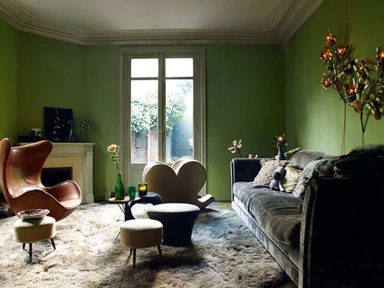The living room is done in green, there are flower and leaf shaped lamps, faux fur and velvet, bold chairs The living room is done in green, there are flower and leaf-shaped lamps, faux fur and velvet, bold chairs