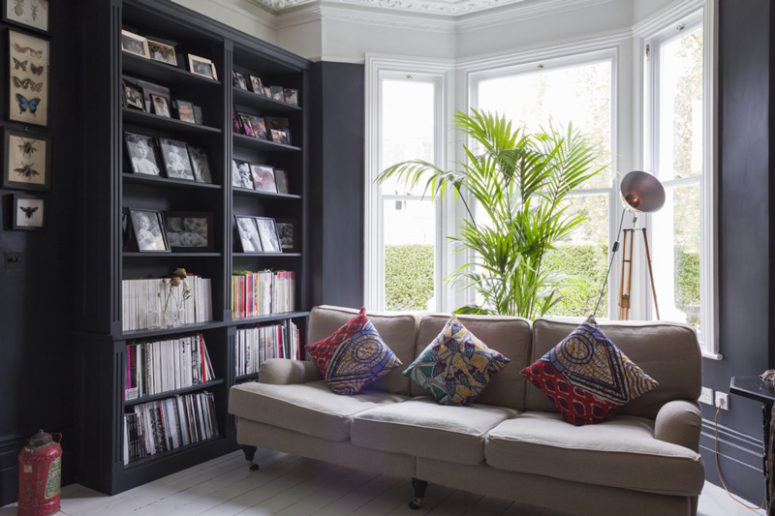 moody room design The living room is moody and dark, with lots of bookshelves and fresh greenery to make it fresher