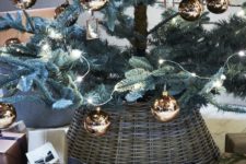 02 a Christmas tree with copper ornaments and a basket that hides the tree base