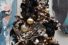 02 a black Christmas tree decorated in gold and silver for a chic gothic-inspired look