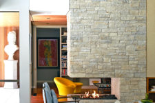 03 The stone-clad fireplace wall divides the living room into two parts