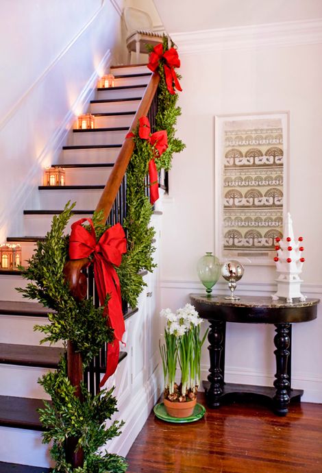 boxwood garland with red bows and lanterns on the stairs