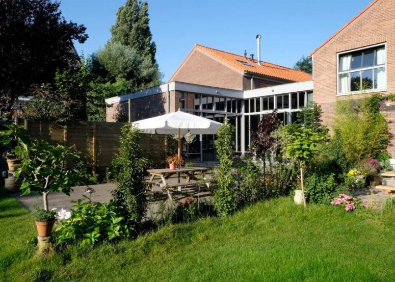 The outdoor spaces are welcoming and inviting, full of greenery, which can be seen through the windows of the house The outdoor spaces are welcoming and inviting, full of greenery, which can be seen through the windows of the house