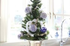 04 a tabletop tree placed in a gold urn with blue and white ornaments