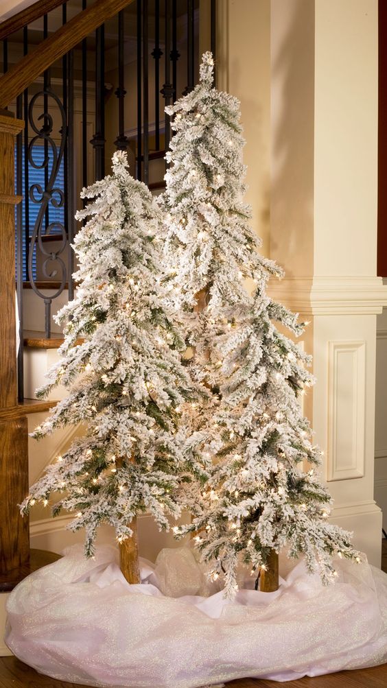 flocked tree trio with lights and white fabric to cover and imitate snow